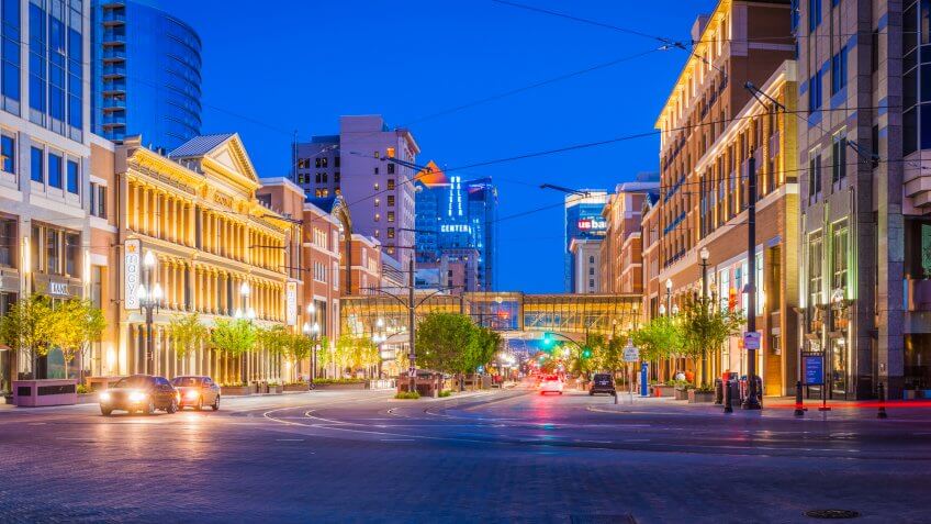 Deep blue desert dusk skies over the street lights, traffic, tram lines, illuminated store fronts and businesses of Main Street, Salt Lake City, Utah.