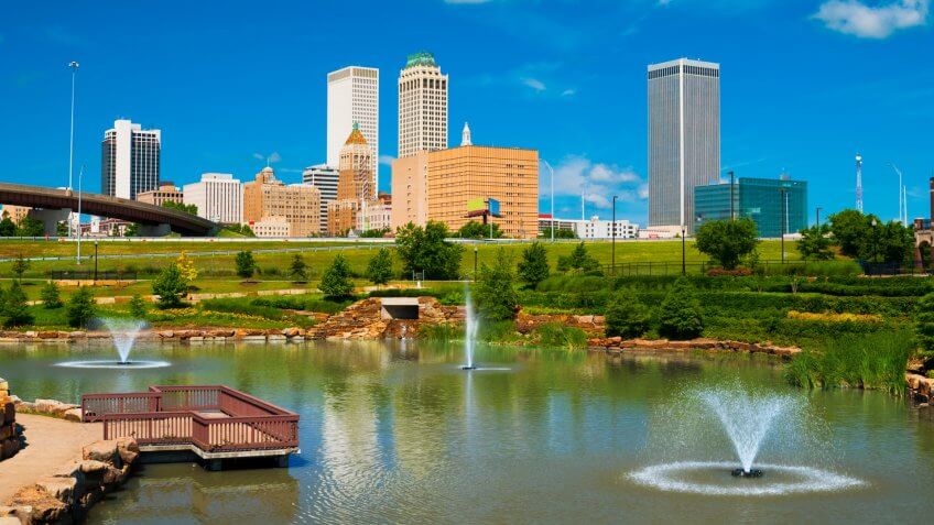 "Tulsa skyline with a park, pond, and fountains in the foreground.