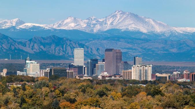 With the snow covered Longs Peak part of the Rocky Mountains and the iconic flatirons of Boulder in the background, Downtown Denver skyscrapers including the iconic 