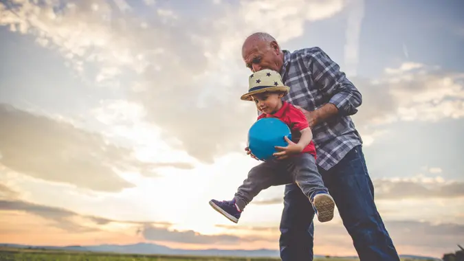 Grandfather and grandson playing with a ball and having fun together.