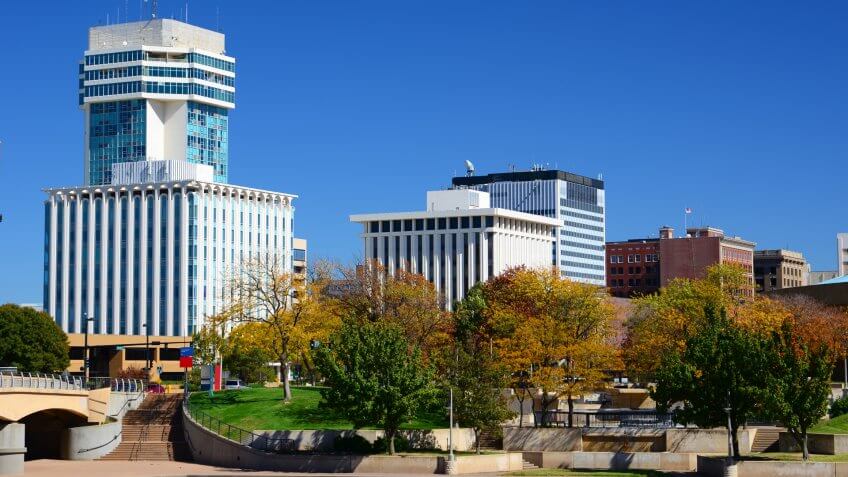 Wichita, Kansas downtown skyline during Autumn, with Autumn trees in the foreground.