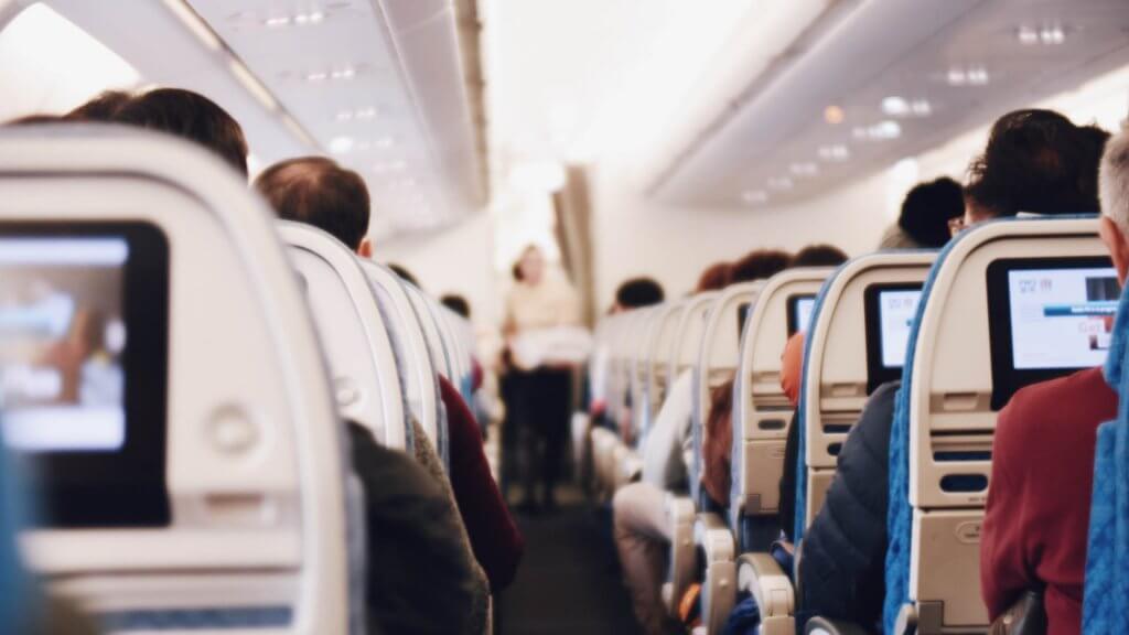passengers on an airplane watching entertainment