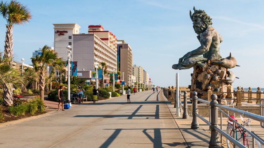 VIRGINIA BEACH, VIRGINIA - JULY 13, 2017: The King Neptune statue by sculptor Paul DiPasquale along the 3-mile long oceanfront boardwalk lined with high-rise hotels.