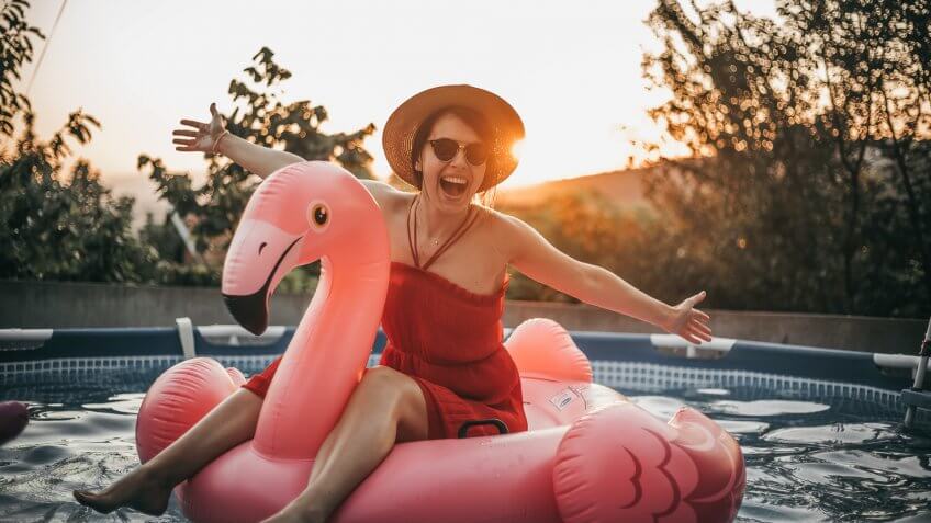 woman on inflatable flamingo in pool
