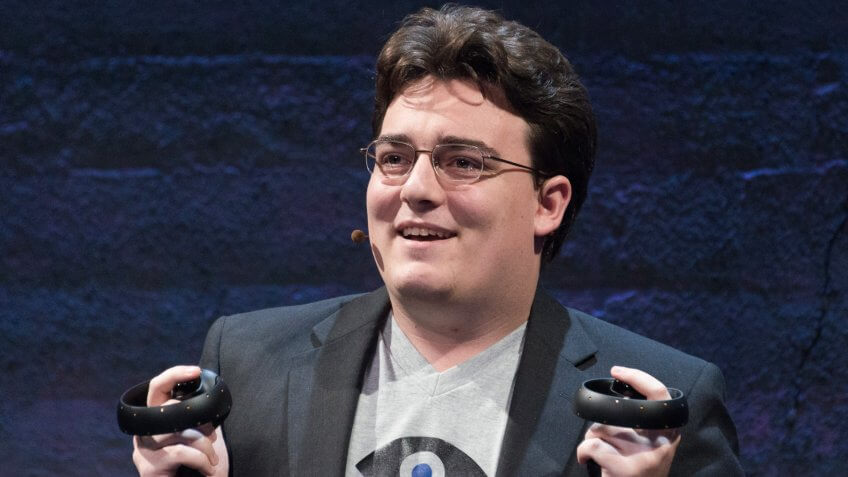 Palmer Luckey (Founder, Oculus) holding up to chest Oculus Touch prototype Half Moon at Step into the Rift.