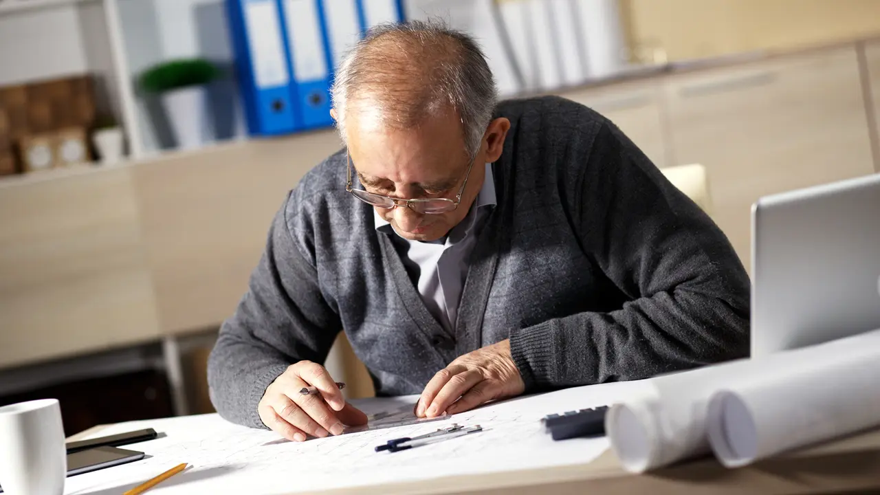 Elderly man working in an office at desk