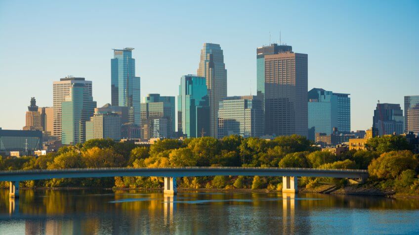 View of Downtown Minneapolis with the Mississippi River and a bridge during the early morning of an Autumn day.