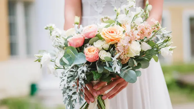 Beautiful wedding bouquet in hands of the bride.