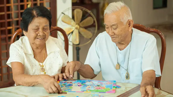 Elderly couple leisurely playing a puzzle game