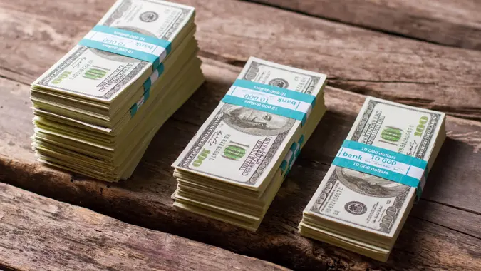 Dollar bundles on wooden background.