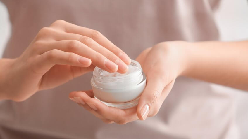 Hands holding a skin care lotion product