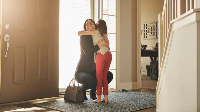 Shot of a happy mother arriving home to a loving welcome from her daughter.