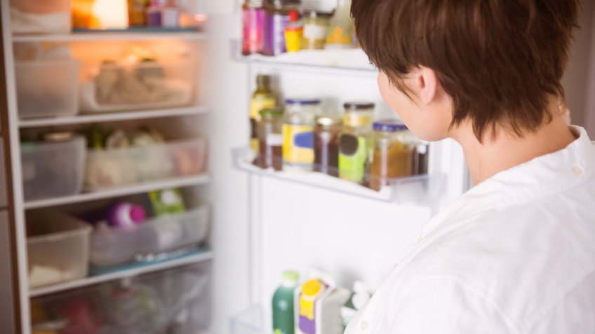 Woman looking into refrigerator