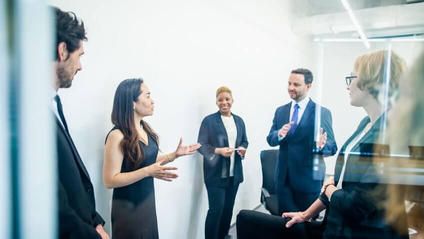 Group of colleagues having business meeting in office.