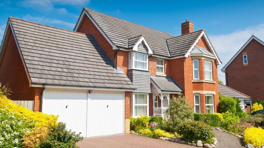 Pretty newly built homes and gardens against a clear blue summers sky.