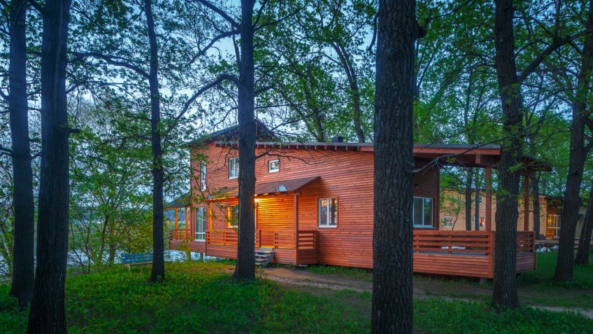 minimalistic wooden house in oak forest in summer