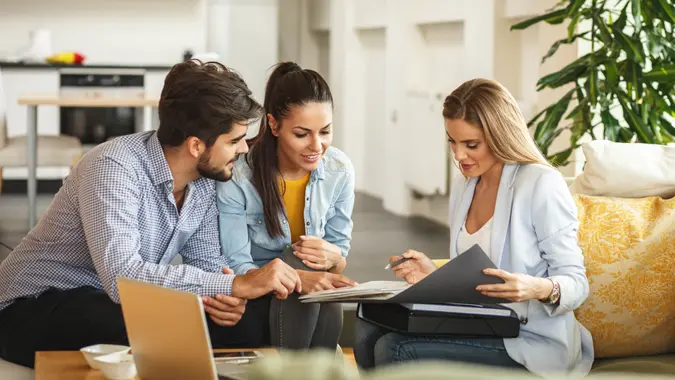 fees, America, money, payment, avoid fees, bills, debt, Female Real Estate agent offer home ownership and life insurance to young couple.