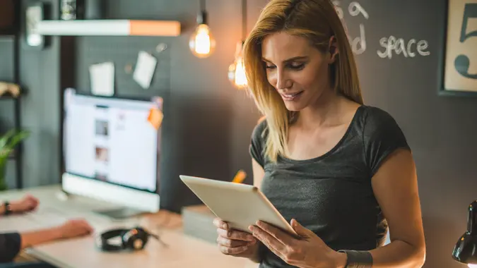 Young attractive businesswoman surfing the net on a digital tablet.