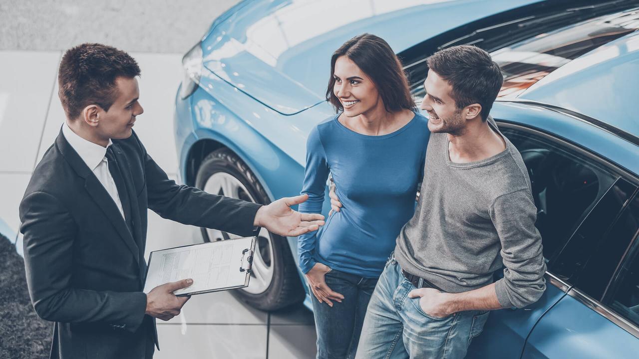 car dealership agent with couple