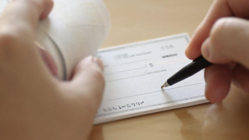 Businessman prepare writing check in the office.