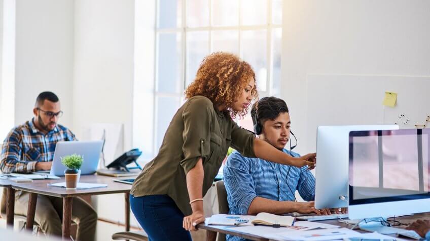 phone operator speaking with a coworker at his desk