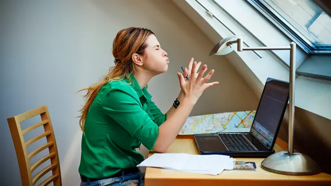 side view of freelancer woman working from home, feeling angry on her hard work, negative attitude,.