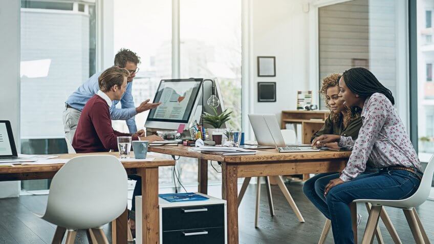 group of colleagues working together at their desks in a modern office
