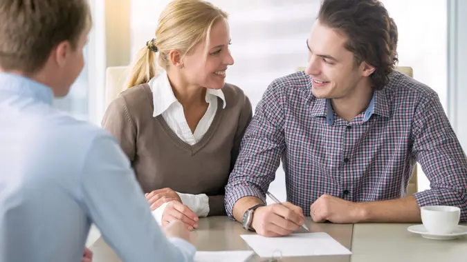 Young smiling couple signing a loan stock photo