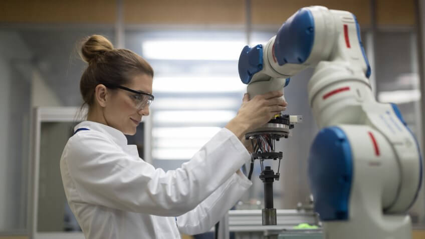 engineers working with robotic arm