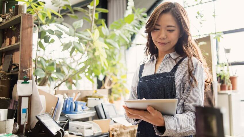 Female gardener working in flower shop.