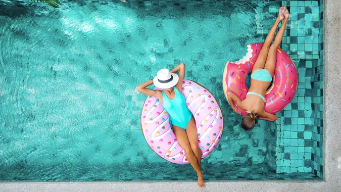 two women in blue swimming pool on innertubes