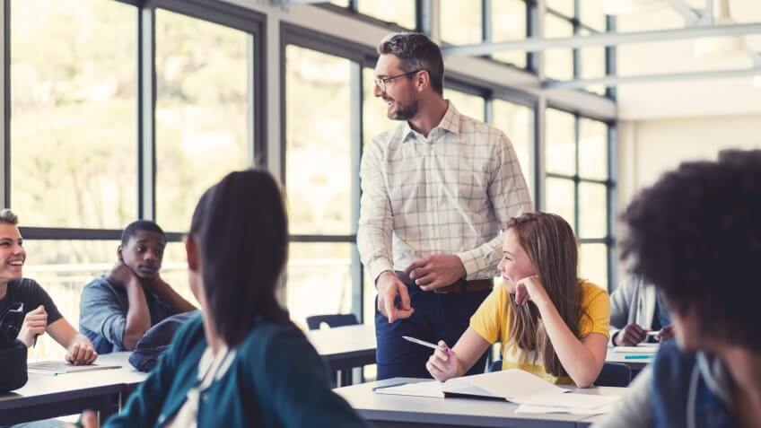 Smiling mature professor teaching in classroom.