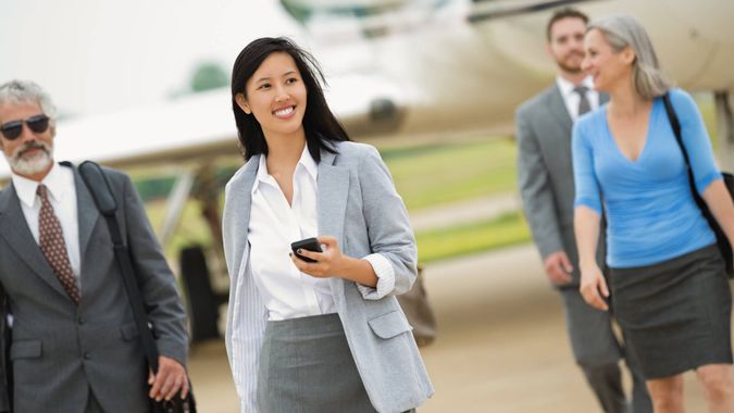 Business executives deboarding private corporate jet.