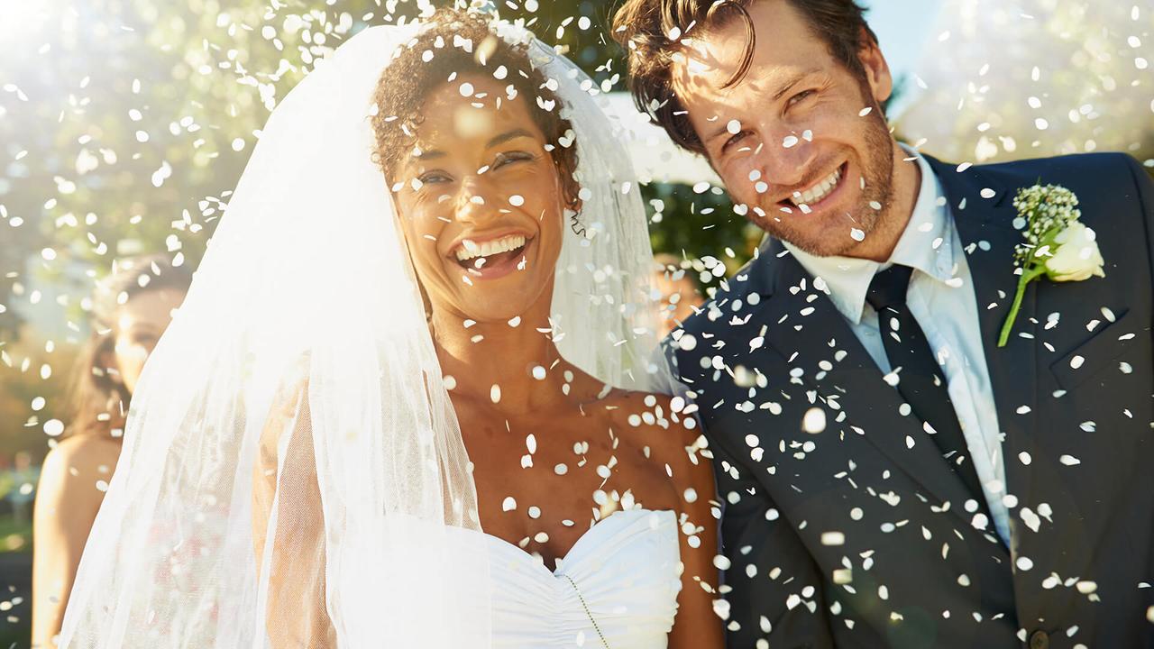 Shot of a happy newlywed couple being showered with confettihttp://195.