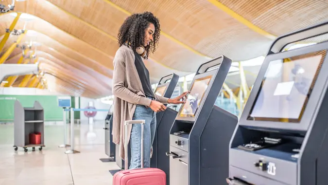 woman using the check-in machine at the airport