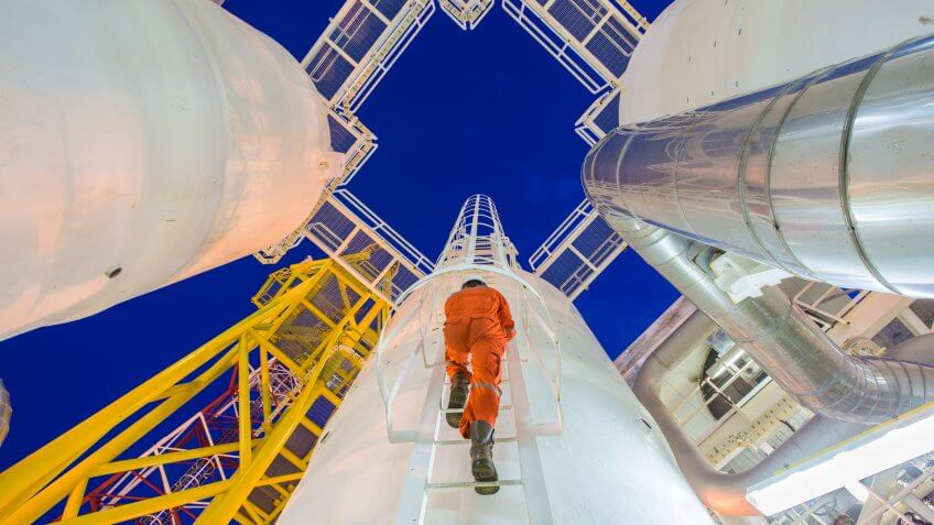 Engineering climb up to oil and gas process plant to observer gas dehydration processing in night shift.