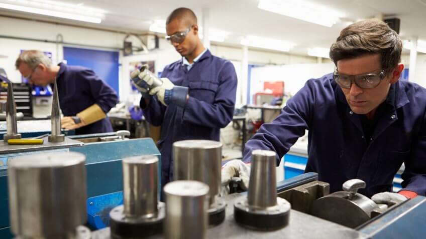 Busy Interior Of Workers In Engineering Workshop.