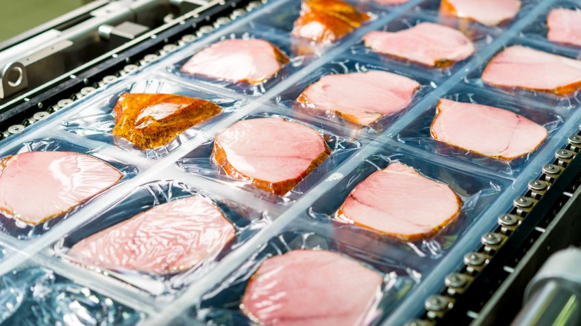 Several chunks of raw meat being processed packaged and shipped.