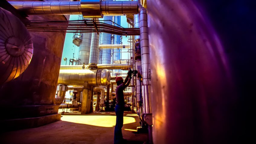 Oil and gas industry worker checking tanks