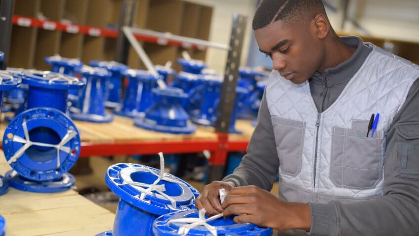 Young man working on parts for a vehicle in the automotive industry