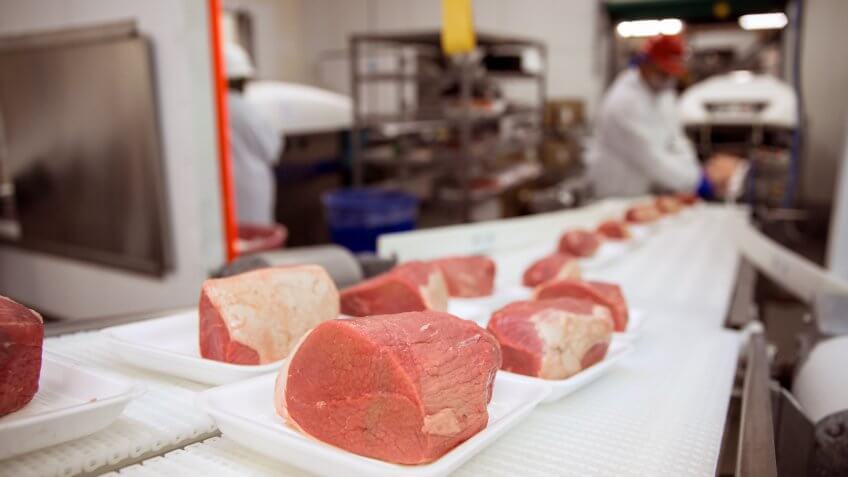 Slabs of meat being prepared for packaging in a production line