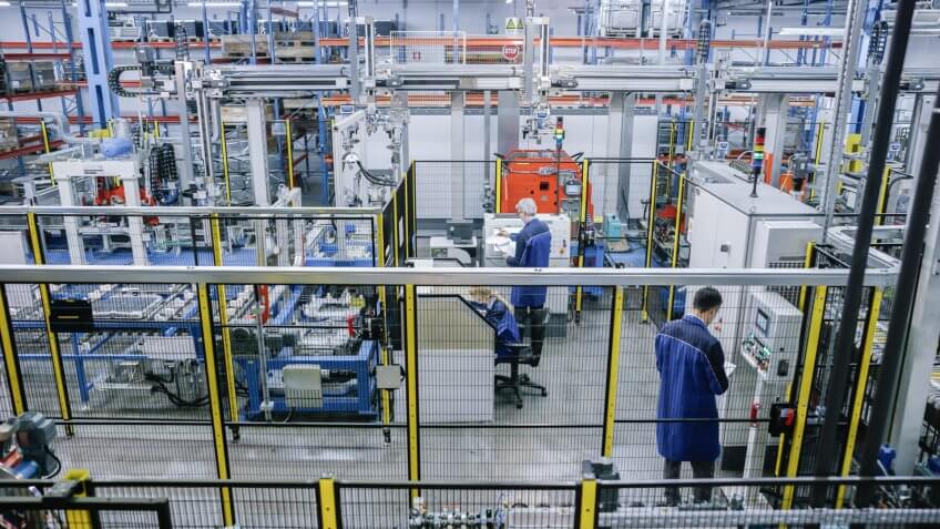 Factory workers working on production line in appliance manufacturing factory.