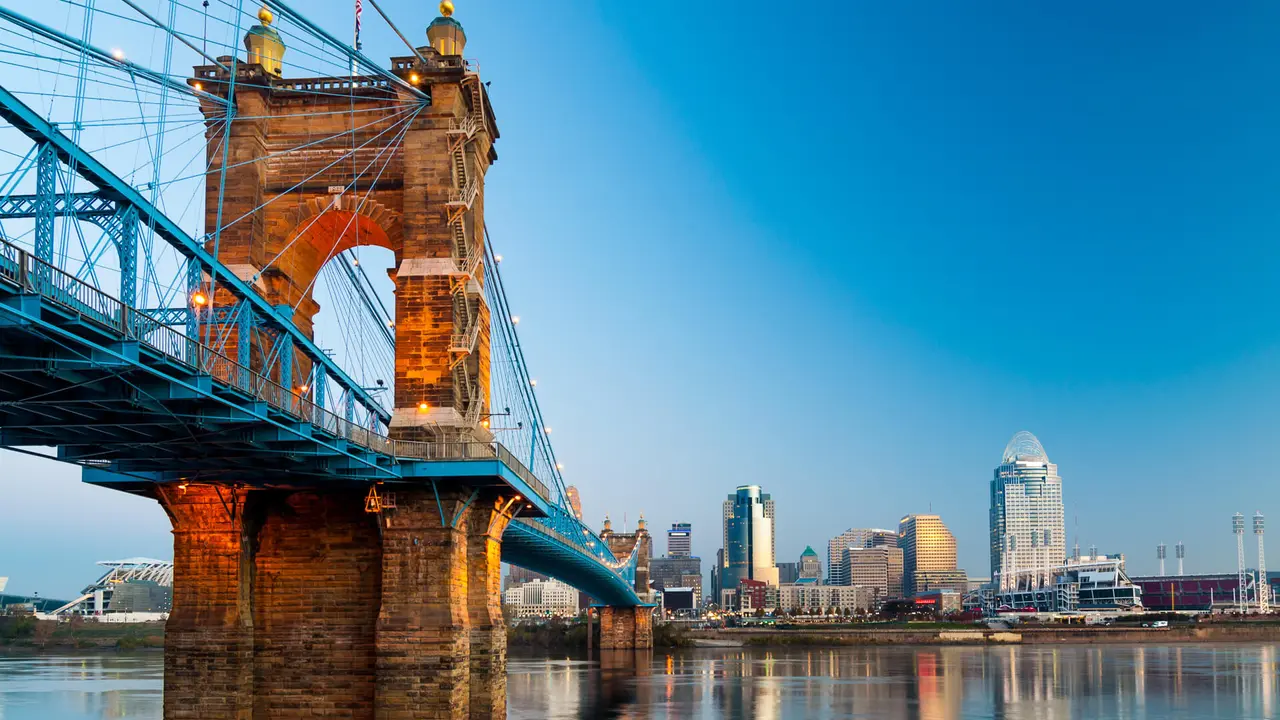 Downtown Cincinnati skyline on the right and the Roebling Suspension Bridge on the left, during dawn, as viewed from Covington, Kentucky.