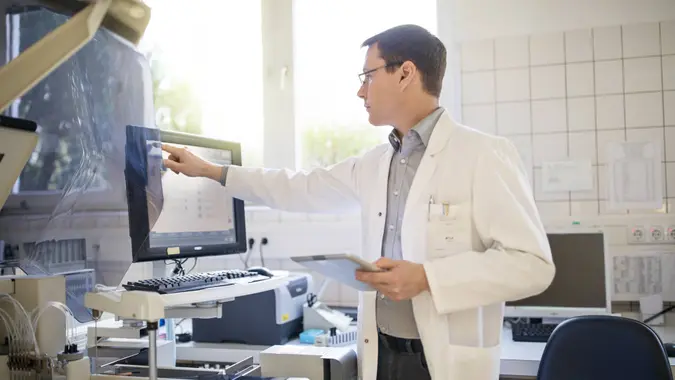 Male scientist using computer at hospital.