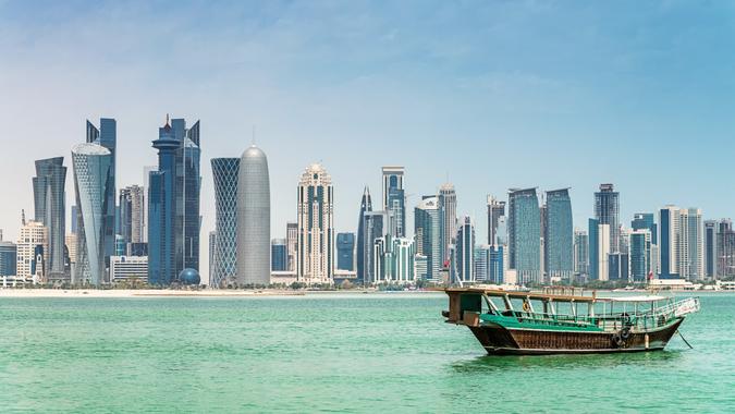 Traditional Dhow cruising in Doha Bay towards Doha Skyscraper Skyline.