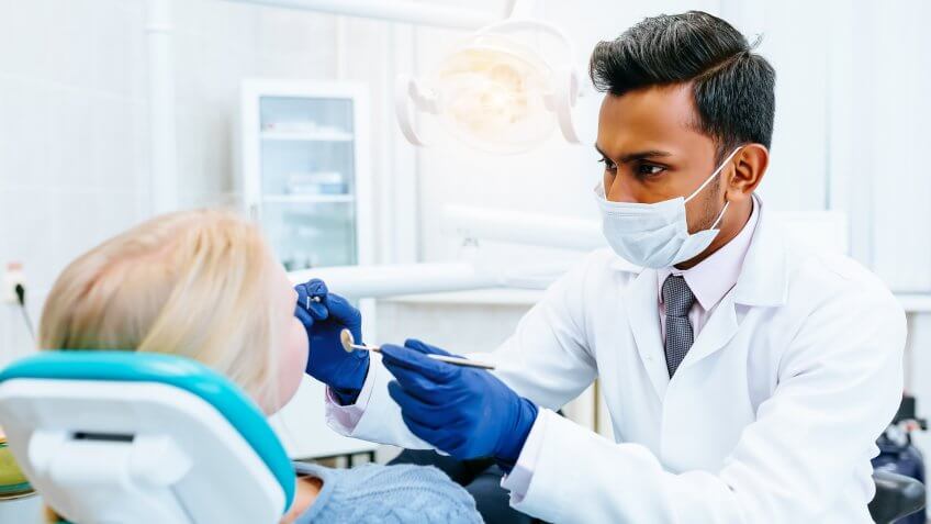 Male dentist Medical treatment to a female patient at the clinic