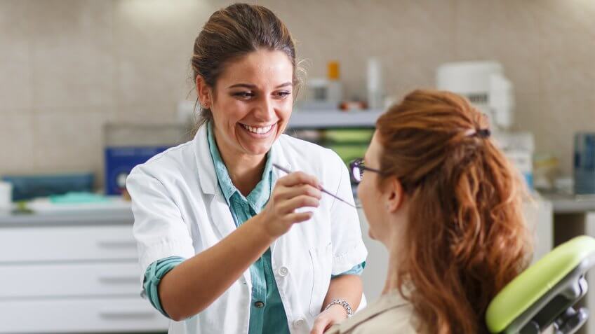 Orthodontist checking teeth of a young patient