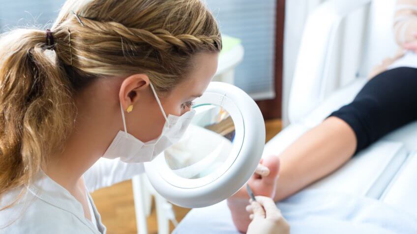 Podiatrist examining foot of a patient