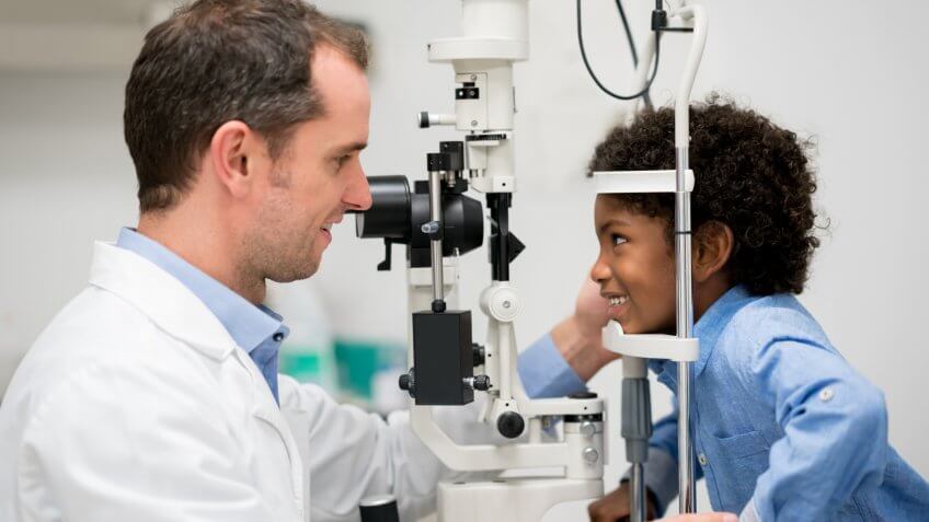 Boy getting an eye exam with an optometrist