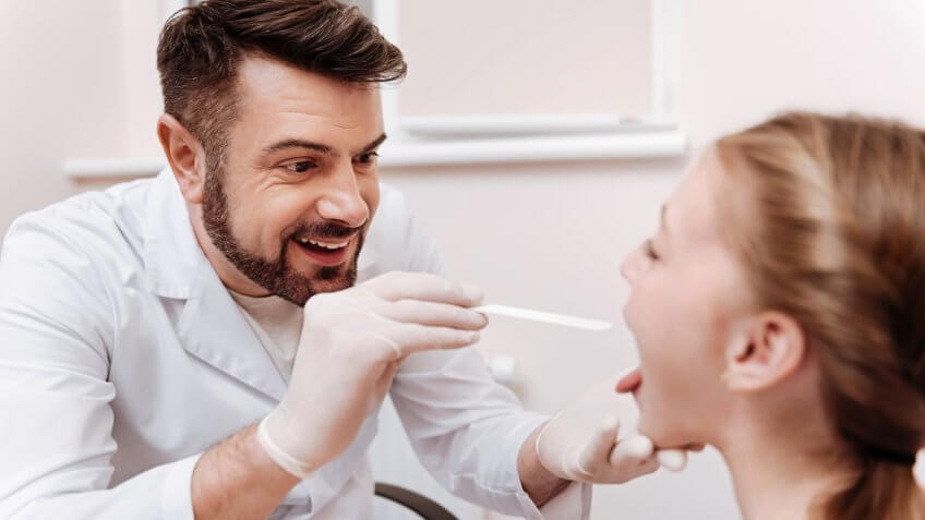 Attentive nurse practitioner conducting throat exam